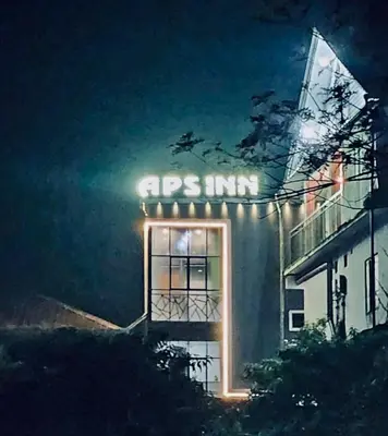 a lit up sign on the side of a building at Aps inn munnar in Munnar