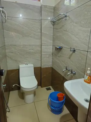 a bathroom with a toilet and a sink and a shower at RF Tower Lodge in Kozhikode