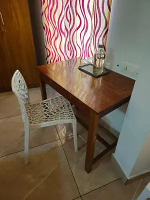 a wooden table and a chair with a candle on it at RF Tower Lodge in Kozhikode