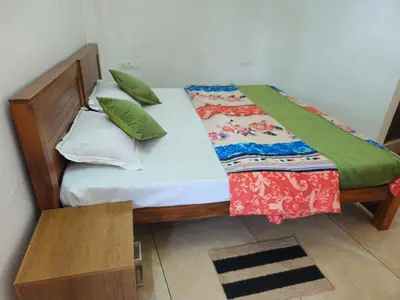 a bed with green pillows on it in a room at RF Tower Lodge in Kozhikode