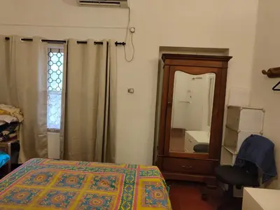 a bedroom with a bed and a dresser and a mirror at Deshadan's Kesarvilla in Palakkad