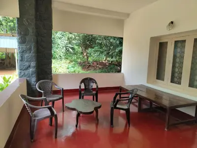 a dining room with chairs and a wooden table at Deshadan's Kesarvilla in Palakkad