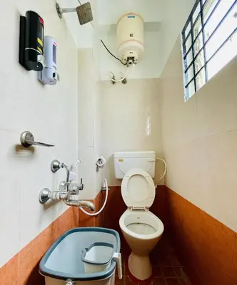 a small bathroom with a toilet and a window at Anand's Elegant 2BHK Apartment - AC in Mysore