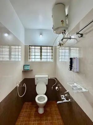 a bathroom with a toilet and a sink at Anand's Elegant 2BHK Apartment - AC in Mysore