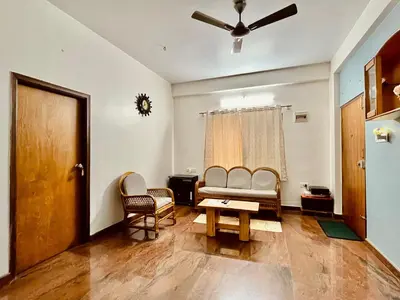 a living room with a couch and chairs and a table at Anand's Elegant 2BHK Apartment - AC in Mysore