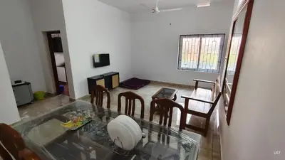 a living room with a glass table and chairs at Happy Homes in Palakkad