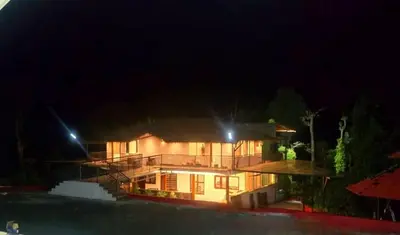 a large house at night with lights on it at Hermitage in Kurchi