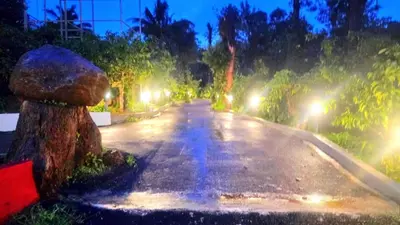 a wet road with a water fountain in the middle at Hermitage in Kurchi
