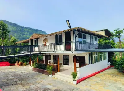 a house with a balcony and a courtyard at Hermitage in Kurchi