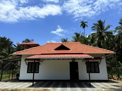 a small white house with a red roof at Horegallu Homes in Agali