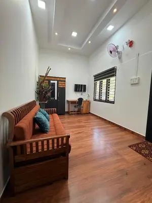 a living room with a couch and a wooden floor at Horegallu Homes in Agali