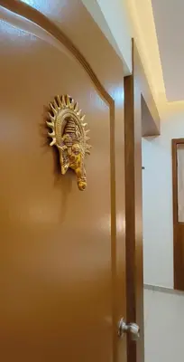 a gold door with a lion head on it at Radha Madhavam Apartment's in Guruvāyūr