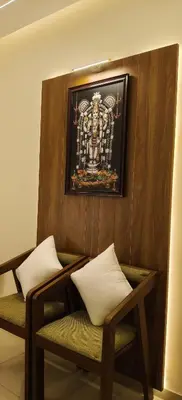 a room with two chairs and a picture on the wall at Radha Madhavam Apartment's in Guruvāyūr