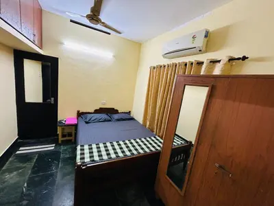 a small bedroom with a bed and a mirror at Bluebell Homes A - 3 BHK Near to Calicut in Beypore