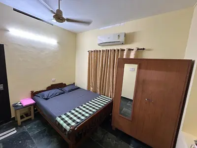 a small bedroom with a bed and a mirror at Bluebell Homes A - 3 BHK Near to Calicut in Beypore