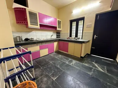 a kitchen with colorful cabinets and a black door at Bluebell Homes A - 3 BHK Near to Calicut in Beypore