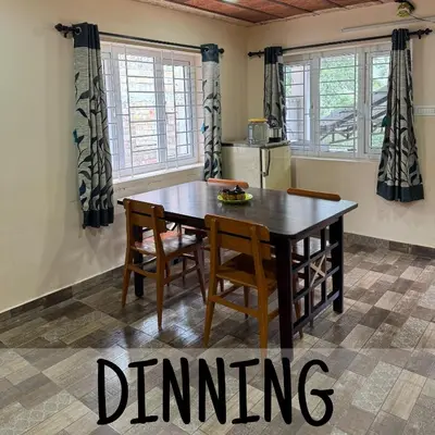 a dining room table and chairs in a kitchen at Ambassador Inn in Kodaikānāl