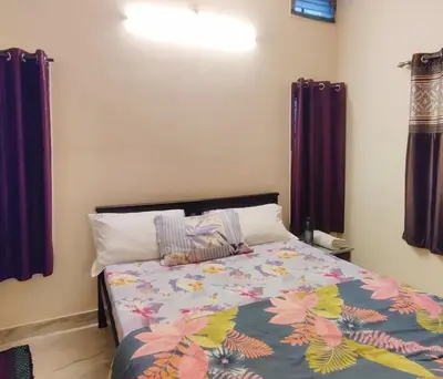 a bedroom with a bed with a colorful comforter at Spacious #1BHK Home Stay in Central #Mysore in Mysore