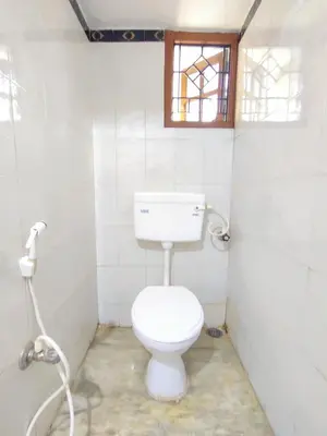 a white bathroom with a toilet and a window at Spacious #1BHK Home Stay in Central #Mysore in Mysore