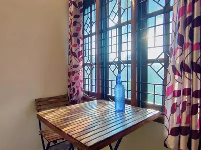 a blue bottle sitting on a wooden table in front of a window at Spacious #1BHK Home Stay in Central #Mysore in Mysore