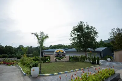 a garden with a roundabout in front of a house at Tuskers Hill Banquets by Poppys - Anaikatti in Palakkad