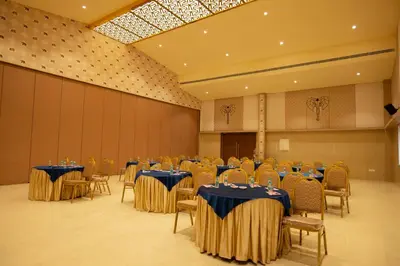 a banquet hall with tables and chairs in a room at Tuskers Hill Banquets by Poppys - Anaikatti in Palakkad