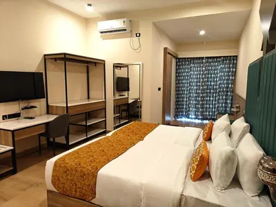 a hotel room with a large bed and a desk at Tuskers Hill Banquets by Poppys - Anaikatti in Palakkad