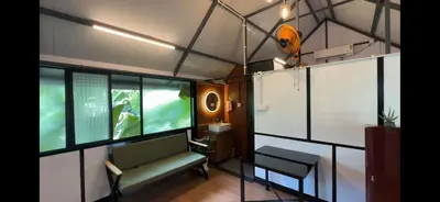 a room with a bench and a table and some windows at damora in Mannārakkāt