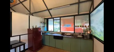 a large kitchen with green cabinets and large windows at damora in Mannārakkāt