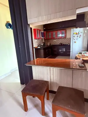 a kitchen with a counter and a refrigerator at Spacious 3BHK Mountain View -walk to palani temple in Palani
