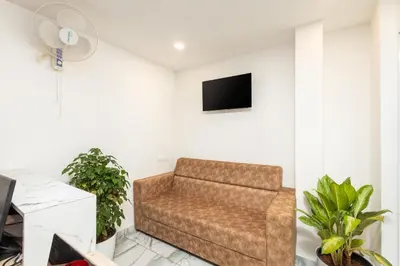 a living room with a couch and a tv at Simqo By Nexa Hotels Group in Kozhikode
