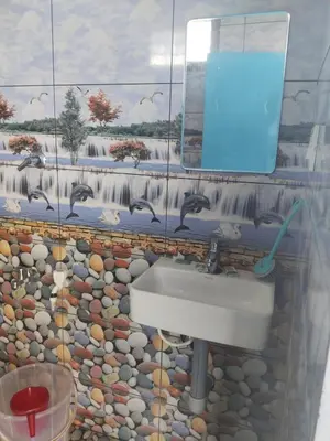 a bathroom with a sink and a mosaic wall at Nachiyar Hotel in Kanthalloor