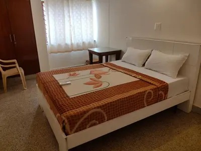 a bedroom with a bed with a painting on it at Cabana 2bhk Elite in Mysore