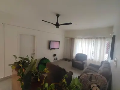 a living room with a couch and a ceiling fan at Cabana 2bhk Elite in Mysore