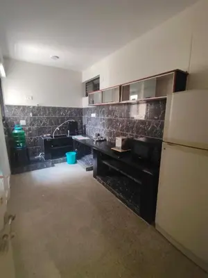 a kitchen with a black counter and a white refrigerator at Cabana 2bhk Elite in Mysore