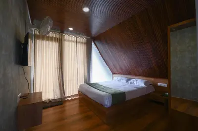 a bedroom with a bed and a large window at Nirvana-Vadanappally Beach Villa in Irimbranallūr