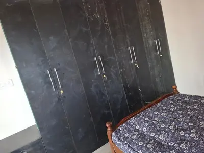 a room with a black wall with two doors at Belaku in Chāmundi