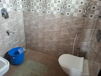 a bathroom with a toilet and a sink at Belaku in Chāmundi