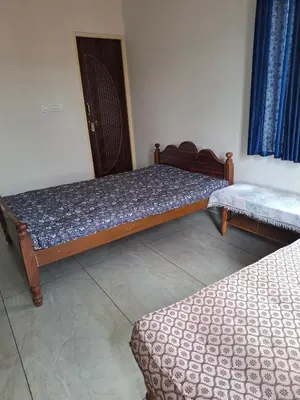 a bedroom with two beds in a room at Belaku in Chāmundi