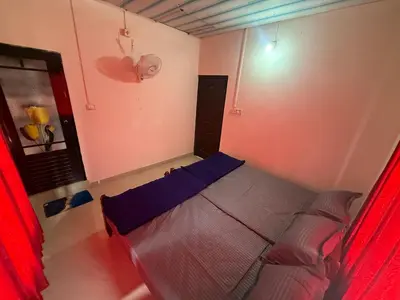 a bedroom with a bed with red curtains at Cosy Kalpetta Villa in Kalpetta