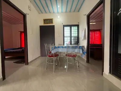 a dining room with two chairs and a table at Cosy Kalpetta Villa in Kalpetta