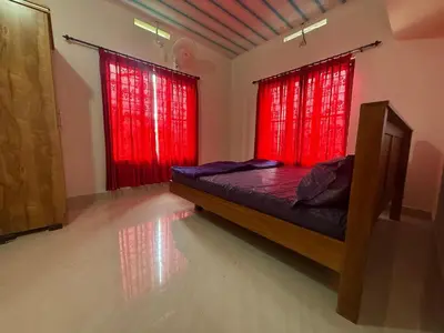 a bedroom with red curtains and a bed in a room at Cosy Kalpetta Villa in Kalpetta