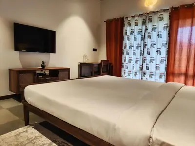 a bedroom with a large bed and a large window at Birdwing - Experiential Farmstay Resort by GoodEarth