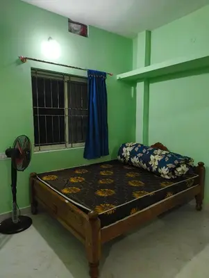 a bedroom with a bed in a room with a fan at Coorg Refresh Homestay in Kushālnagar