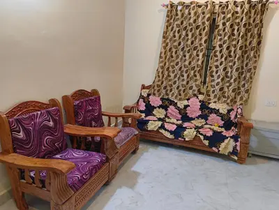 two chairs and a curtain in a room at Coorg Refresh Homestay in Kushālnagar