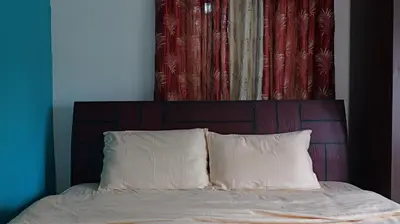 a bed with two pillows and a wooden headboard at Happy Villa By Eden Luxury Stay in Ooty