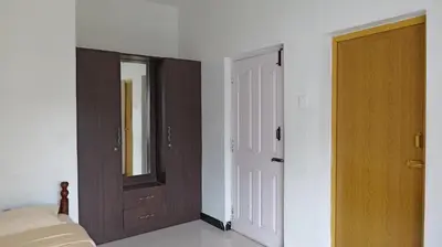 a bedroom with a door and a bed and a mirror at Happy Villa By Eden Luxury Stay in Ooty