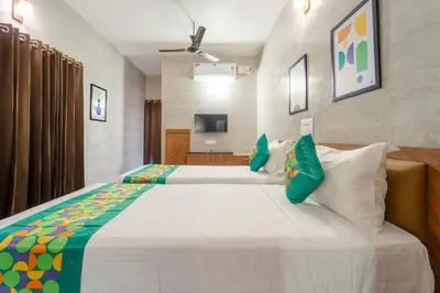 a bedroom with a large white bed with green pillows at Treebo Dunag in Coimbatore