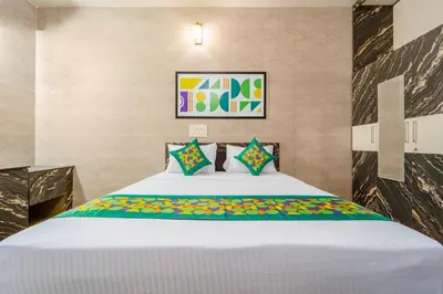 a bedroom with a white bed with colorful pillows at Treebo Dunag in Coimbatore