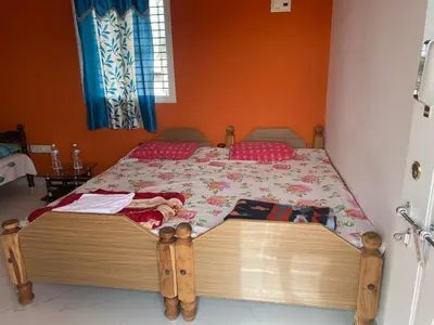 a bedroom with a bed with a wooden frame at Abhi home stay in Mysore